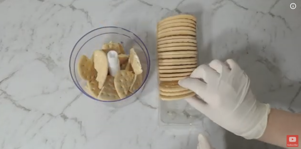 Placing Arrowroot biscuits in a blender.