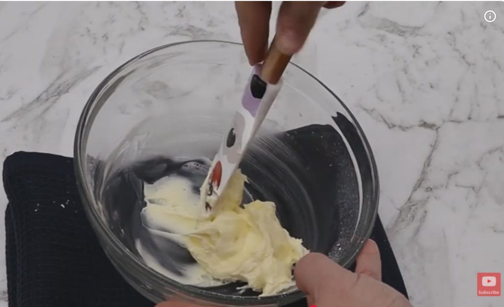 Monte Carlo filling in a glass bowl with a spatula mixing it.