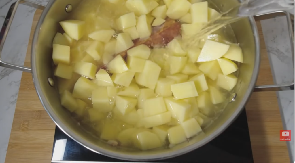Pot on a convection cook top in the pot onion, bacon, garlic, bacon bones, stock and potato.