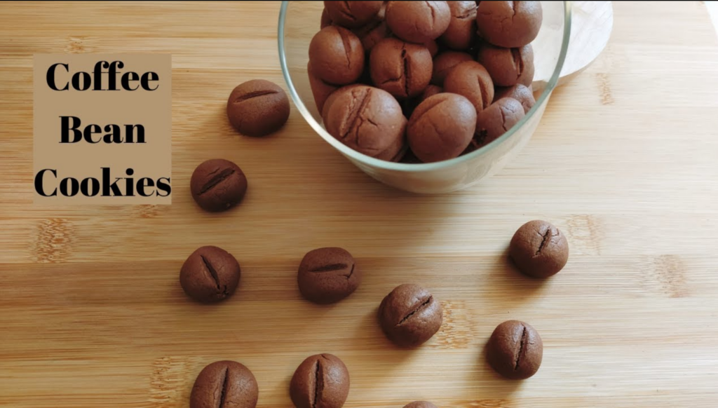 Coffee Bean Shaped Cookies in a jar with some scattered around the bench