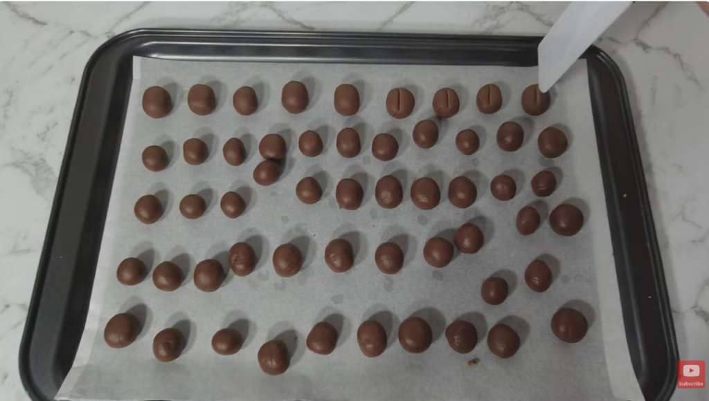 Lined baking tray with coffee bean cookies ready to be placed in the fridge.