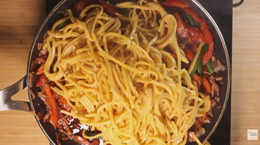 Adding Hokkien Noodles to the bacon and veg in the frying pan.