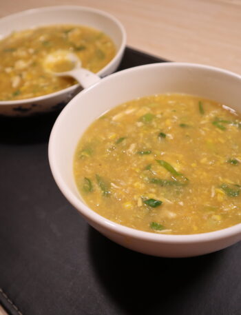 Bowl of chicken and sweet corn soup topped with spring onions