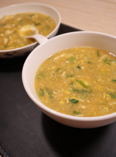 Bowl of chicken and sweet corn soup topped with spring onions