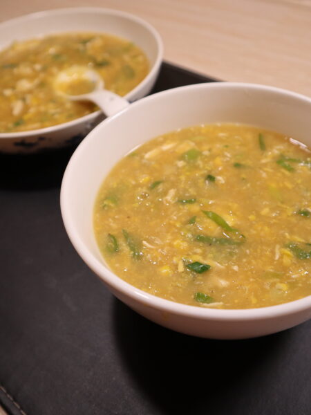 Bowl of chicken and sweet corn soup topped with spring onions