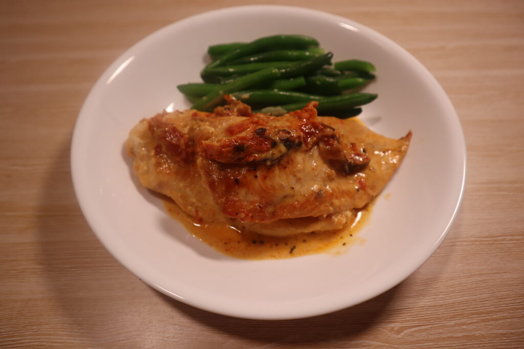 Marry Me Chicken on a plate with green beans