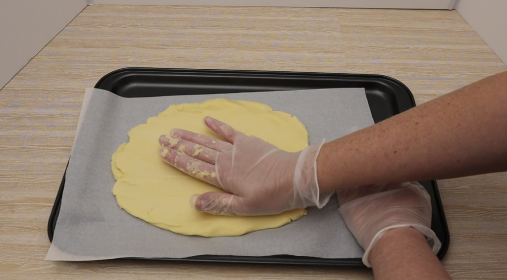 Shortbread being spread on the baking tray.