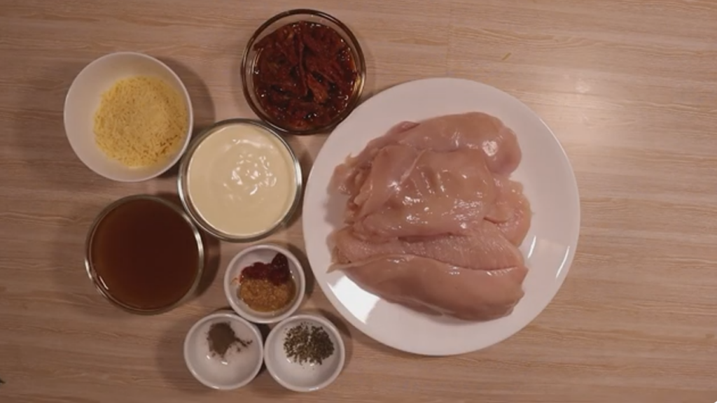 Ingredients for Marry Me Chicken in small bowls and chicken breast on a plate