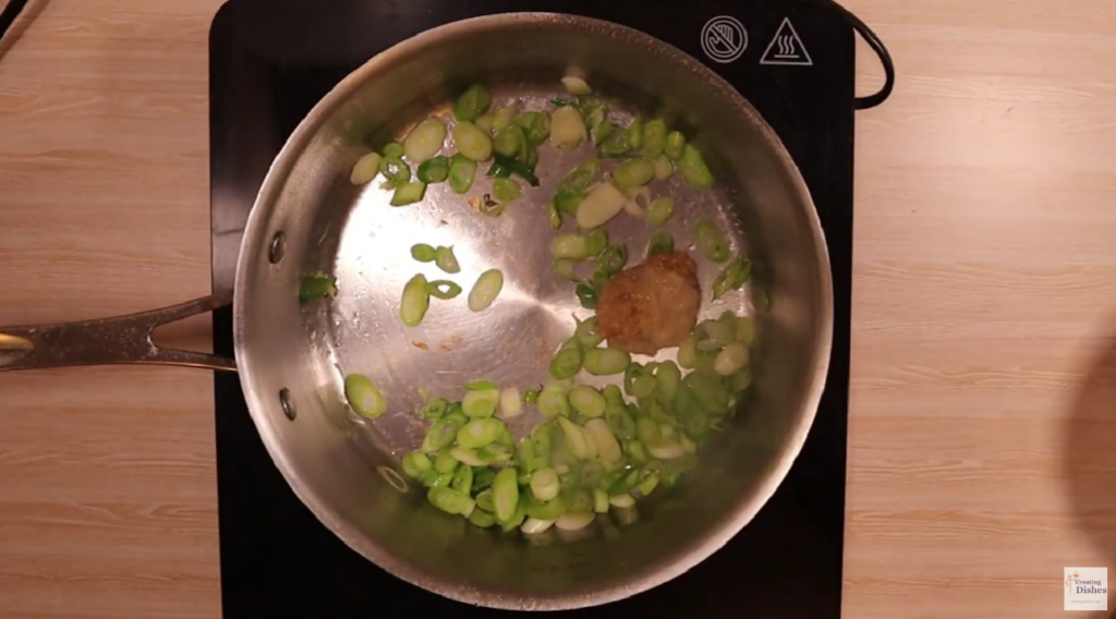 Saucepan with spring onions, garlic and ginger.