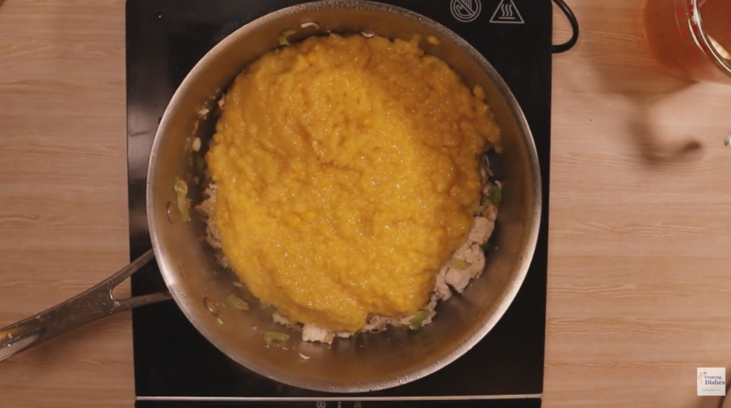 Saucepan with creamed corn being added to chicken and sweet corn soup
