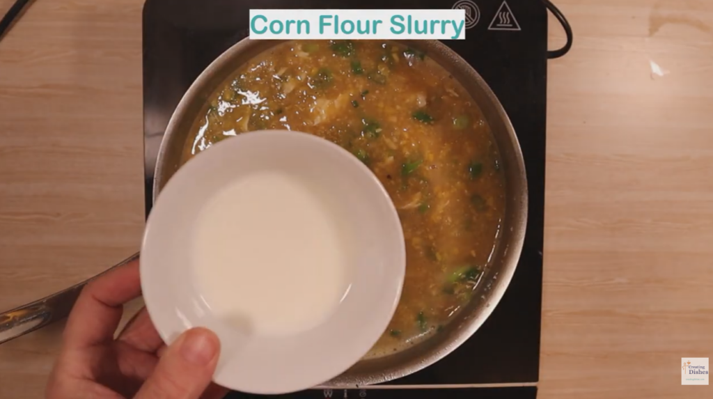 Bowl of corn flour slurry being added to chicken and sweet corn soup