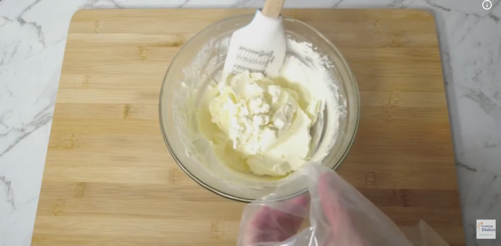 Glass bowl with whipped cream ready for the piping bag.