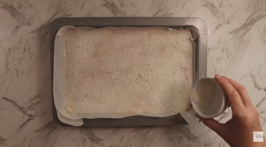 Sprinkling coconut over the icing
