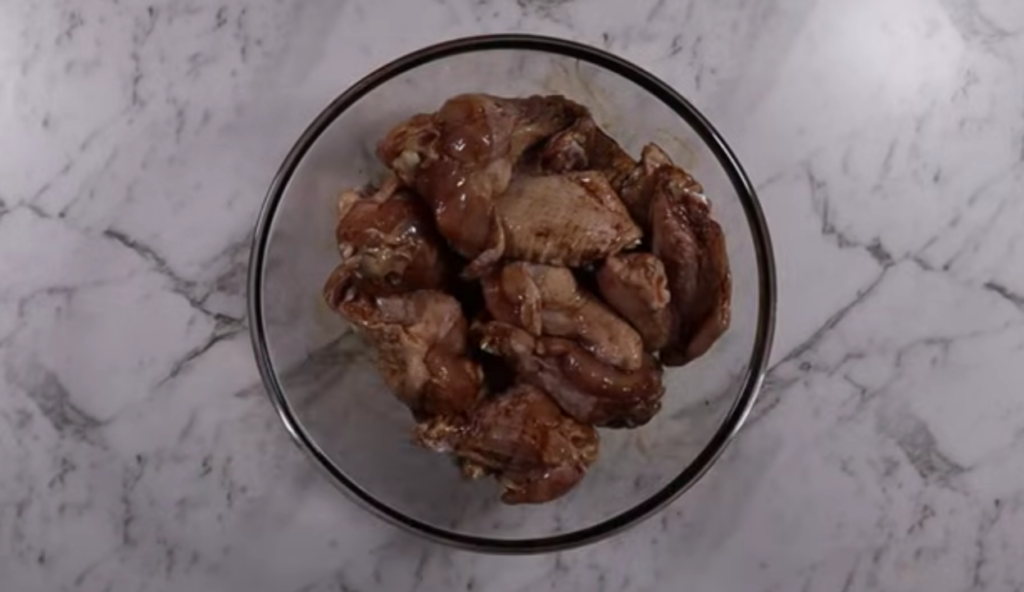 Chicken wings with soy sauce in a glass bowl.